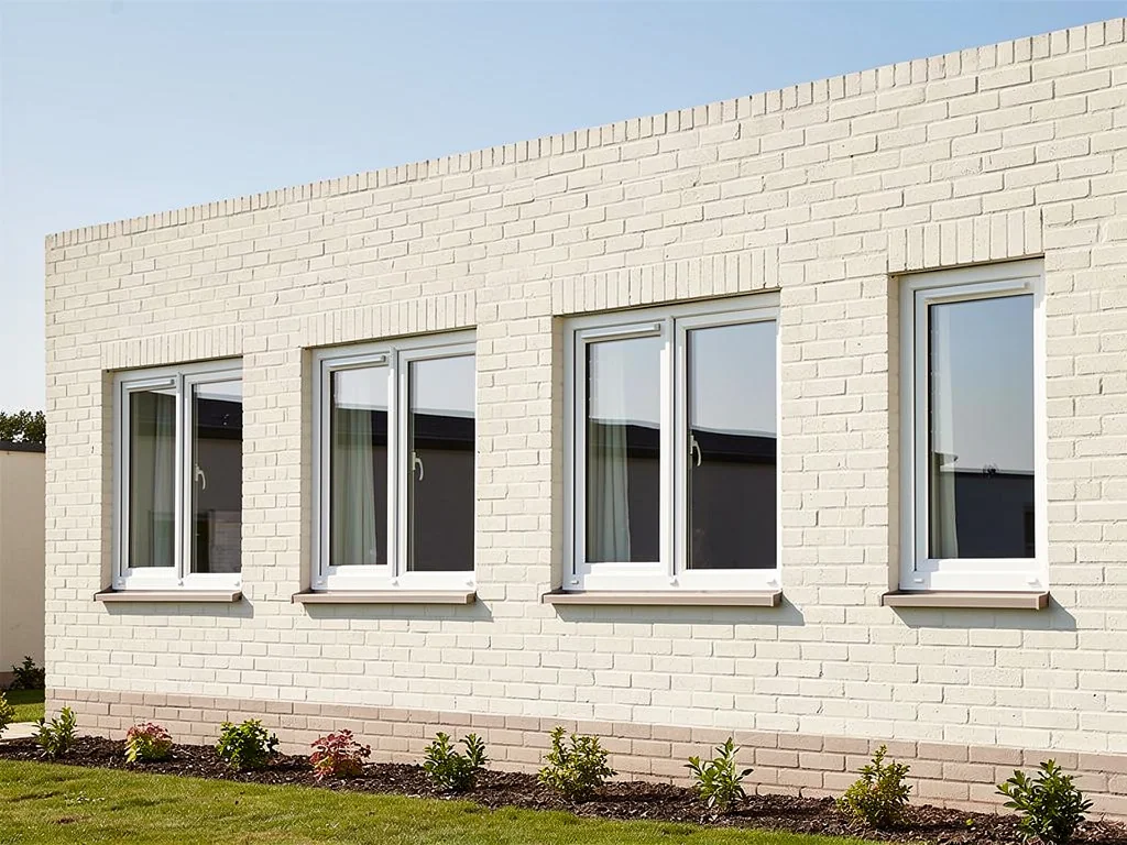 Rangée de fenêtres PVC neuves sur une façade de maison rénovée